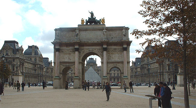 Durch den Triumphbogen kann man den Eingang des Louvres sehen